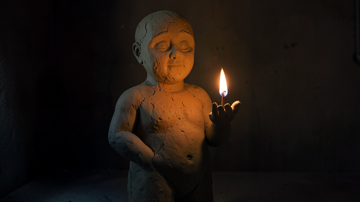 A large rough clay figure standing still while a small bright flame burns steadily in its open palm, the flame representing understanding that the golem carries but does not possess